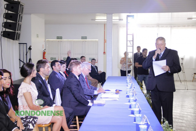 Vice-prefeito eleito Ilário Hoffstetter prestando juramento. 
Da esquerda a direita:  vereador Adriano Cottica (meio rosto), Márcio Veit, Josiane Laborde Rauber, prefeito eleito Márcio Rauber, vereador Nilson Hachmann,  vereador Pedro Hachmann, vereador Adriano Backes e vereador Arion Nasighil. 
Imagem: Acervo Memória Rondonense - Crédito: Tioni de Oliveira