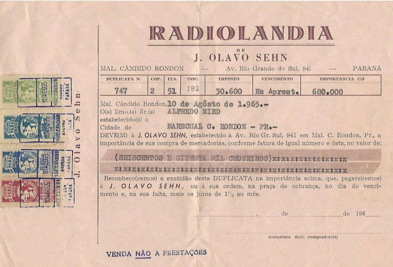 Cópia de duplicata emitida pela Radiolândia,  empresa de J. Olavo Sehn, referente a venda de uma vitrola (aparelho de som) ao casal Alfredo e Paulina Nied. 
A Radiolândia estava estabelecida entre a Nied - Construcia e a Rodovel. 
Veja as imagens do citado equipamento de som que hoje pertence a filha do casal Sueli Nied Scherer. 
Imagem: Acervo Walmor Nied 