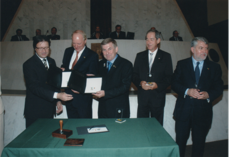 Itamar Ribeiro, diretor dos Correios no Paraná, entregando cada uma das peças assinadas ao embaixador da Alemanha e deputado estadual Elio Rusch e mais o s senhores Hans Gerhard Schorer, cônsul honorário da Alemanha em Curitiba e Wilson Andersen Ballão, agraciados com o selo comemorativo fundido numa peça de acrílico. 