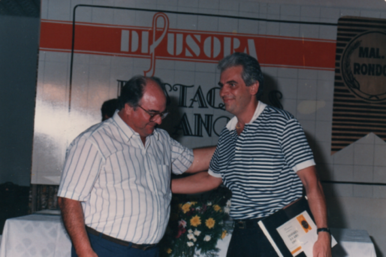 Empresário Renato Kaefer, proprietário da empresa Kaefer Motos Ltda.,  recebendo o prêmio de Destaque 87, no stor de Revendas de Motos e Automóveis, das mãos do empresário e vereador João Natálio Steion, do então distrito rondonense de Entre Rios.
