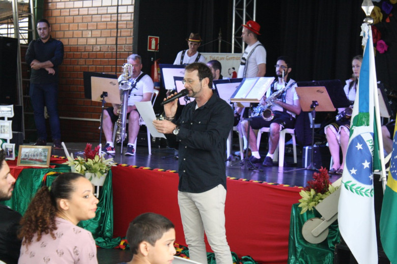 Mestre de Cerimônias César Reck procedendo  abertura oficial da III Mostra de Dança Folclórica de Marechal Cândido Rondon. 
Imagem: Acervo  Imprensa PM-MCR -
 Crédito: Luiz Fernando Cerny - Imprensa - MCR