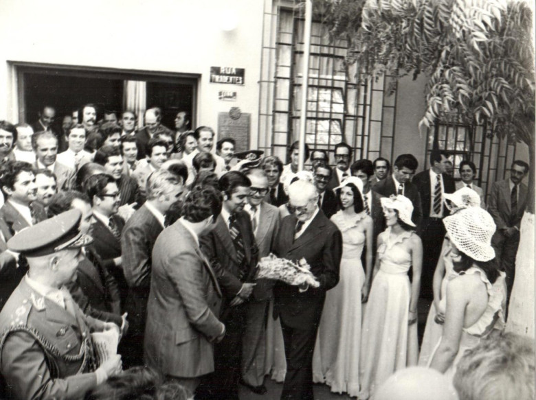 Outro momento da homenagem ao Presidente em nome das cooperativas. 
A direita do Presidente, o agropecuarista Roberto Wypich, de Cascavel, integrante da diretoria da Cotriguaçu. 
À direita, entre as duas árvores: 1º - não identificado; 2º - o agricultor Romano Czerniej, de Cafelândia, dirigente da Cotriguaçu; e 3º Paulo Carneiro Ribeiro, secretário de Agricultura do Paraná. 
