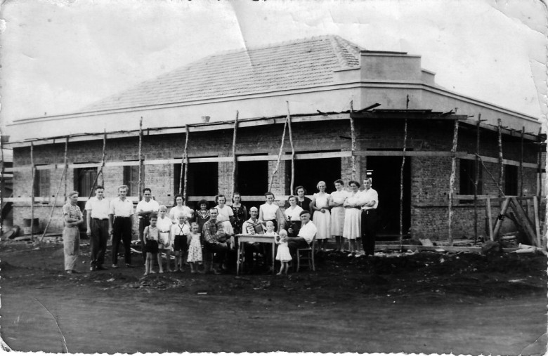 Novo prédio da casa comercial de Alfredo e Paulina Nied, em construção em 1954, na esquina da Avenida Rio Grande do Sul com a Rua D. João VI, no sentido leste-oeste. 
A construção hoje revitalizada abriga atualmente a empresa Constru & Cia., pertencente aos herdeiros. 
O pioneiro Alfredo Nied é a 4ª pessoa, da esquerda à direita. 
O senhor de acordeão é o professor Waldomiro Liessem. 
Imagem: Acervo Sueli Nied Scherer