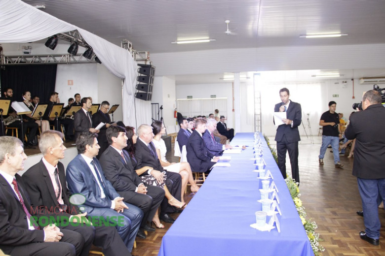 Prefeito eleito Márcio Andrei Rauber prestando juramento na sessão solene de posse. 
Da esquerda a direita: deputado estadual Elio Rusch, vereador Adelar Neumann, vereador Cláudio Köhler,  vereador Adriano Cottica, Márcia Veit, vice-prefeito Ilário Hofstetter, Josiane Laborde Rauber, vereador Nilson Hachmann, vereador Pedro Raubere vereador Adriano Backes. 
Imagem: Acervo Memória Rondonense - Crédito: Tioni de Oliveira