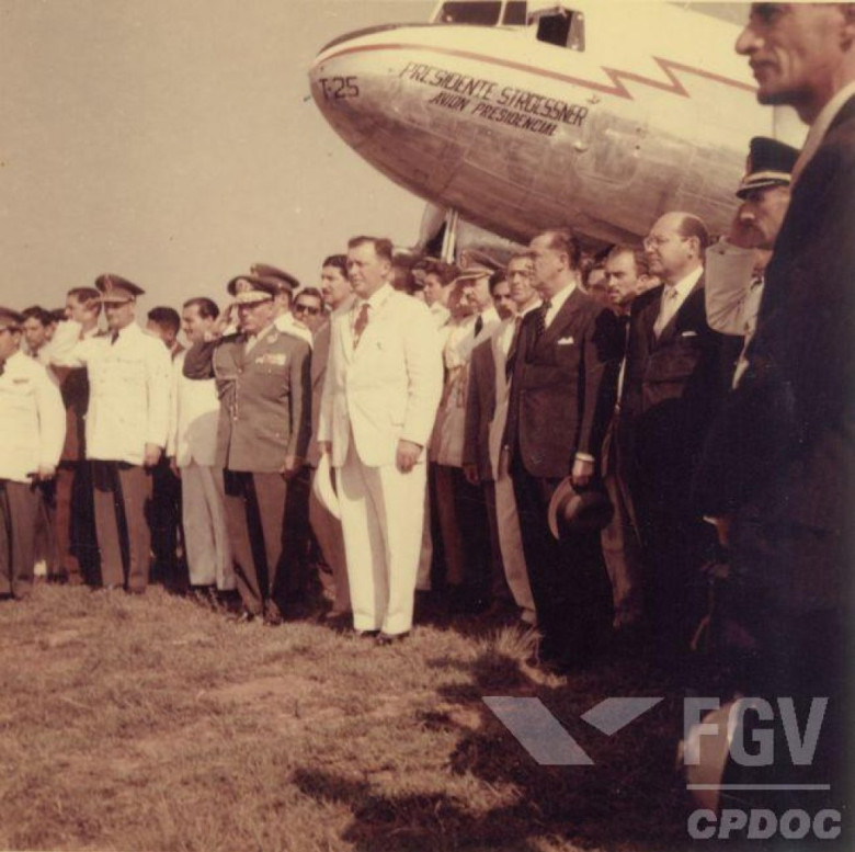 Presidentes Alfredo Stroessner (de branco) e Juscelino Kubitscheck acompanhando a execução dos hinos nacionais do Paraguai e do Brasil.
Imagem: Acervo Wagner Dias  / Facebook.