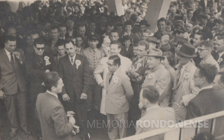 Prefeito de Toledo, Egon Pudell saudando o  governador Moisés Lupion (de óculos), por ocasião de sua visita a Exposição Agropecuária de General Rondon. 
De costas, primeira à direita, senhor Arlindo Alberto Lamb, coordenador-geral da organização e administração da grande exposição. 
Primeira, à esquerda, o pioneiro e vereador Helmuth Koch