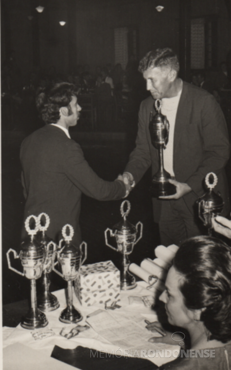 Dealmo Selmiro Poerrsch cumprimentando e premiando outro atleta vencedor.