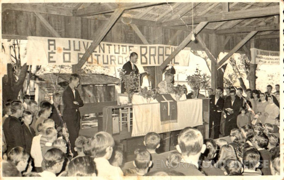 || Culto ecumênico durante a exposição 4-S na sede distrital de Iguiporã.
Da esquerda à direita: de terno escuro e braços cruzados, professor Bruno Bays, da então escola municipal da Linha Ouro Verde; pastor Egon Marterer, da Comunidade Evangélica de Mercedes e, sentado, o padre Antonio Darius SVD . Ainda à direita, de terno escuro: Léo Müller e Hugo Uhlen (de livro na mão).
Imagem: Acervo Harto Viteck - FOTO 24 -