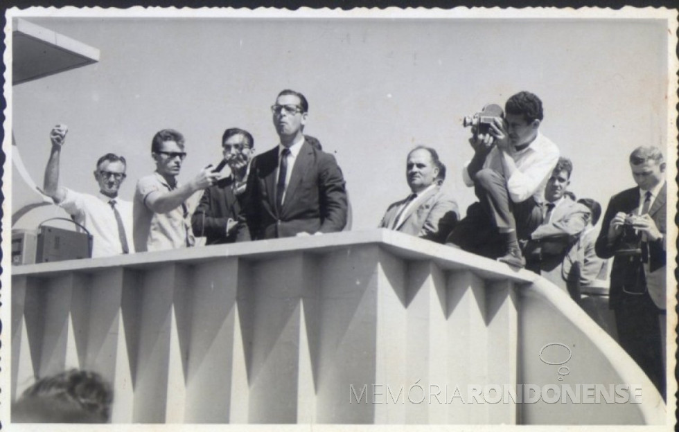 || Governador Paulo Pimentel discursando na Praça Willy Barth, por ocasião de sua visita a Marechal Cândido Rondon. Da esquerda a direita: 1º a 3º - não identificados; 4º - Paulo Pimentel; 5º e 6º - não identificados; 7º - pastor Harald Malschitzky; e 8º Pastor Joachim Pawelke.
Imagem: Acervo Memória Rondonense - FOTO 1 -