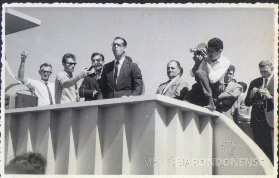 || Governador Paulo Pimentel discursando na Praça Willy Barth, por ocasião de sua visita a Marechal Cândido Rondon. Da esquerda a direita: 1º a 3º - não identificados; 4º - Paulo Pimentel; 5º e 6º - não identificados; 7º - pastor Harald Malschitzky; e 8º Pastor Joachim Pawelke.
Imagem: Acervo Memória Rondonense - FOTO 1 - 