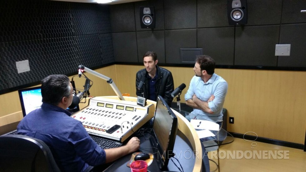 || Marcio  Andrei Rauber entrevistado no estúdio da Difusora FM pelos comunicadores Adriel Marcelo (camisa azul, de costas) e César Rech, à direita de braços cruzados. 
Imagem: e crédito: Tioni de Oliveira - FOTO  11 - 