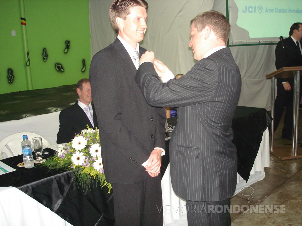 || Jornalista Joni Leocir Lang recebendo o pin de presidente da JCI Marechal Cândido Rondon de seu antecessor Gelson José Linck, em dezembro de 2009.
Imagem: Acervo pessoal - FOTO 17 -