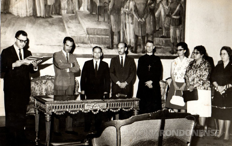|| Sabino dos Santos, Chefe da Casa Civil do Governo Ney Braga, fazendo a leitura do termo de criação da Fundepar, em julho de 1962.
Da esquerda à direita, depois do Chefe da Casa Civil, 1º - governador Ney Braga, 2º não identificado. engenheiro e professor Francisco Borsari Neto (?), Irmão Albano (marista do Colégio Santa Maria - Curitiba), professora Maria Lourdes Zanardini, professora Cecília Westphalen, docente doa UFPR e PUCPR; e Nair Macedo, direretora do Grupo Escolar Tiradentes, de Curitiba, em 1962.
Imagem: Acervo Paulo José da Costa (Curitiba) - FOTO 21 -