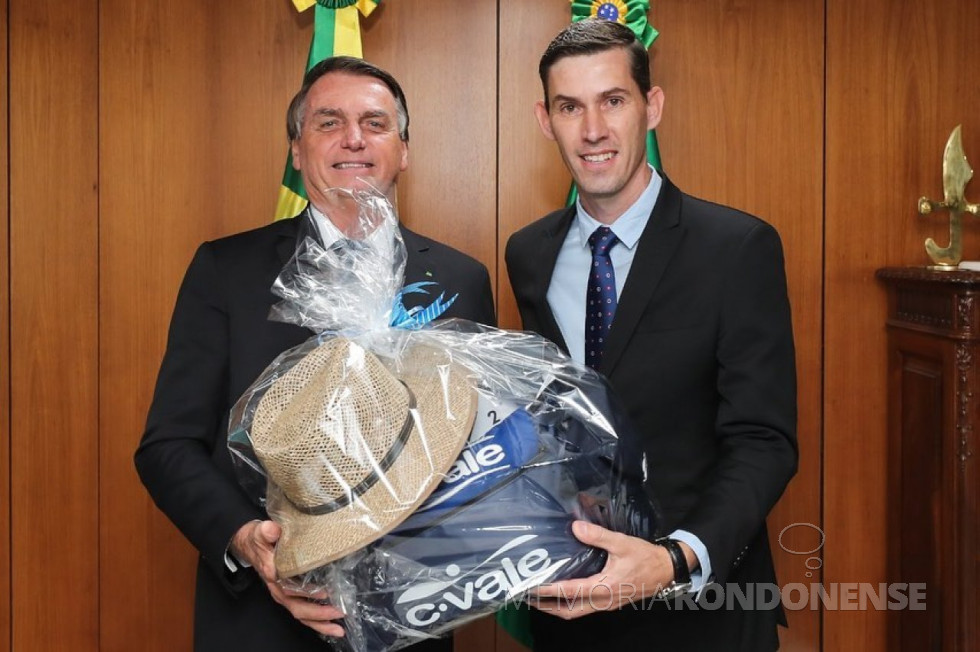 || Anderson Bento Maria (e), entregando ao presidente da República Jair Messias Bolsonaro, um pacote de itens da C-Vale, da cidade de Palotina (PR), em junho de 2022.
Imagem: Acervo pessoal - FOTO 17 -