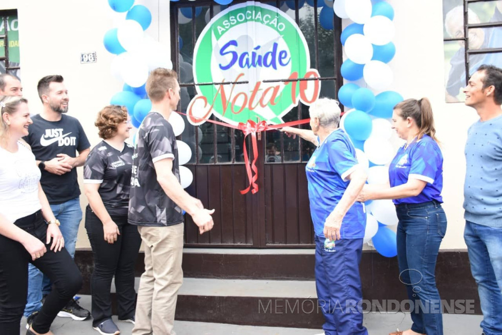 || Inauguração da sede da Associação Saúde Nota 10, na sede distrital rondonense de Porto Mendes.
Da esquerda à direita: Viviane Spier , vereador Cristiano Metzner (Suko), Diogo Schneider (Bolha), secretário municipal de Esporte e Lazer; Graciele e Ademir Biesdorf (primos), Rosina (nascida Bassani) Vasselai (100 anos de idade), Marlizete Odorizzi (neta de Rosina) e Vilmar Germano.
Imagem: Acervo Marlizete Odorizzi - FOTO 21 -