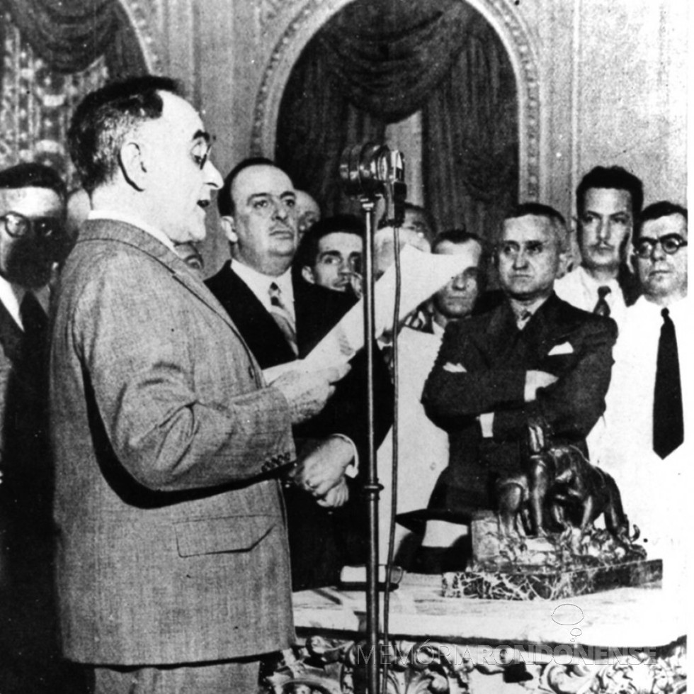 || Getúlio Vargas anuncia pelo rádio o início novo regime ditatorial, em novembro de À sua direita, aparecem o ministro Dutra (de braços cruzados), Filinto Müller (de bigode, atrás dele) e o autor da Constituição, Francisco Campos (extrema direita).
Imagem: Acervo e legenda do Memorial da Democracia - FOTO 6 -