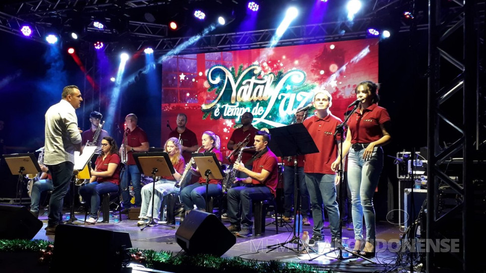 || Show da orquestra de sopros no palco da Praça Dealmo Selmiro Poersch no remate da agenda programática de eventos culturais natalinos, em dezembro de 2022.
Da esquerda à direita: Sentados: Samara Elouise Sobreiro Hernandes - sax tenor, Letícia Guntzel Zang - saxofone soprano, Rosilene Cristina Guntzel - sax soprano e Tiago Oberherr - sax alto.
Em pé: Patrick Furlan Schultz - maestro, Gabriel Cesar Guntzel Urnauer - trombone de vara, Cristiano Stadlober - trompete, Milton Dutra - trombone de vara, Cristiano Gonçalves de Araújo - trompete, Ivanor Eger - trompete, Guilherme Dutra e Elaine Cristina Bueno - vogais.
Não aparecem na foto mas atuaram durante a apresentação: Adelar Zastrow - teclado, Eder Reginaldo Roeder - contrabaixo, Gabriel Trajano Hinkel, trompete, Itamar Dahmer Bade, sax barítono, Maicon Encinas - bateria, Ramon Augusto Sobreiro Hernandes - Sax tenor e Wilson Nelson Mielke (Bill) guitarra.
Estiveram ausentes da orquestra: Edir Prass - trombone de vara e Willian Zastrow - Sax alto.
Imagem: Acervo Imprensa PM-MCR - FOTO 17 -