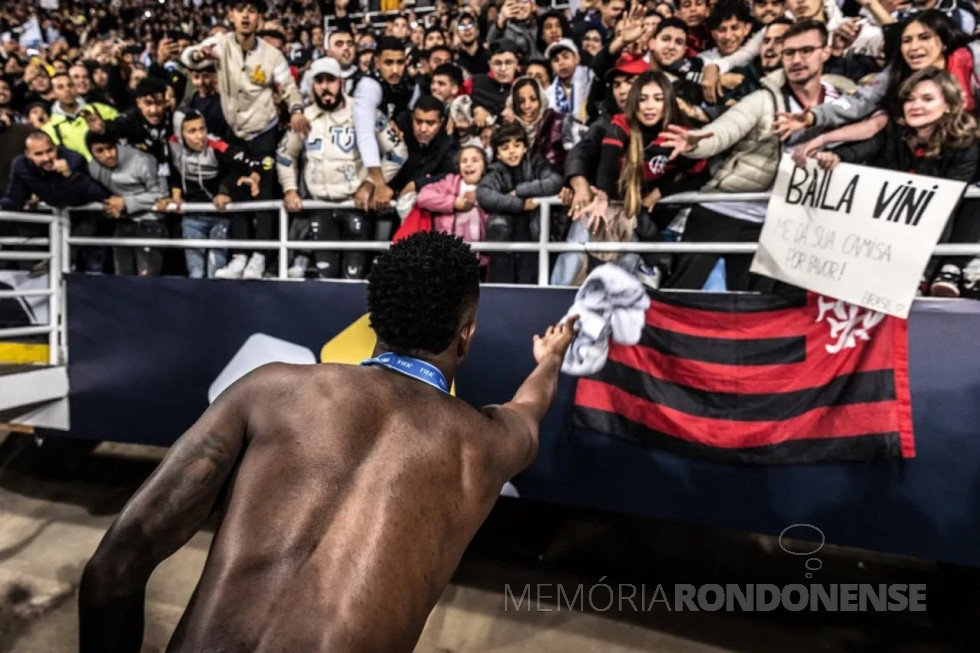 || Jogador Vinícius Junior, do Real Madrid, jogando a  sua camiseta para a rondonense Haidi Gund e filhos depois do jogo com Al Hilal, em fevereiro de 2023.
Imagem: Acervo Globo Esporte - FOTO 16 - 