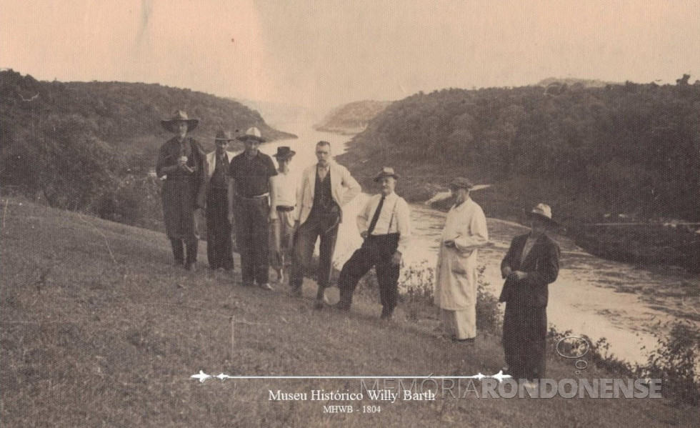 || Miguel Dewes - corretor de terras da colonizadora Maripá, com um grupo de pessoas ( possíveis compradores de terras) do Rio Grande do Sul, em visita  ao extinto Porto Britânia, à margem esquerda do Rio Paraná.
Doado da fotografia: Ondy H. Niederauer, em 23/03/1988. Acervo Museu Histórico Willy Barth - FOTO 10 -