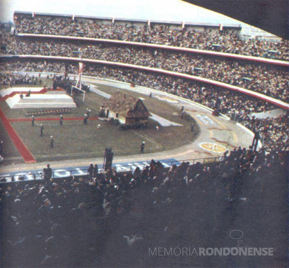 || Estádio Couto preparado para a 1ª missa do Papa João Paulo II, em Curitiba. Vê-se, à direita, a casa polonesa típica, trazida do interior, remontada na praça de esportes, dedicada em sua homenagem pela vasta colônia polonesa existe no Paraná.
Imagem: Acervo CD - FOTO 9 -