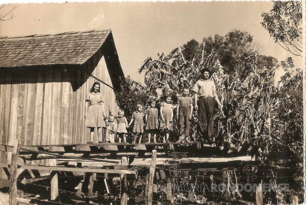 || Casal rondonense pioneiro Odilia e Aorelio Casarotto, com seus primeiros cinco filhos, da esquerda à direita, Marília, Marilene, Marinez, Iracema, Inês e Nadir, junto à primeira moradia em Marechal Cândido Rondon, na Linha Horizonte, na década de 1950.
Imagem: Acervo Lidiane Casarotto Kotz - FOTO 7 -
