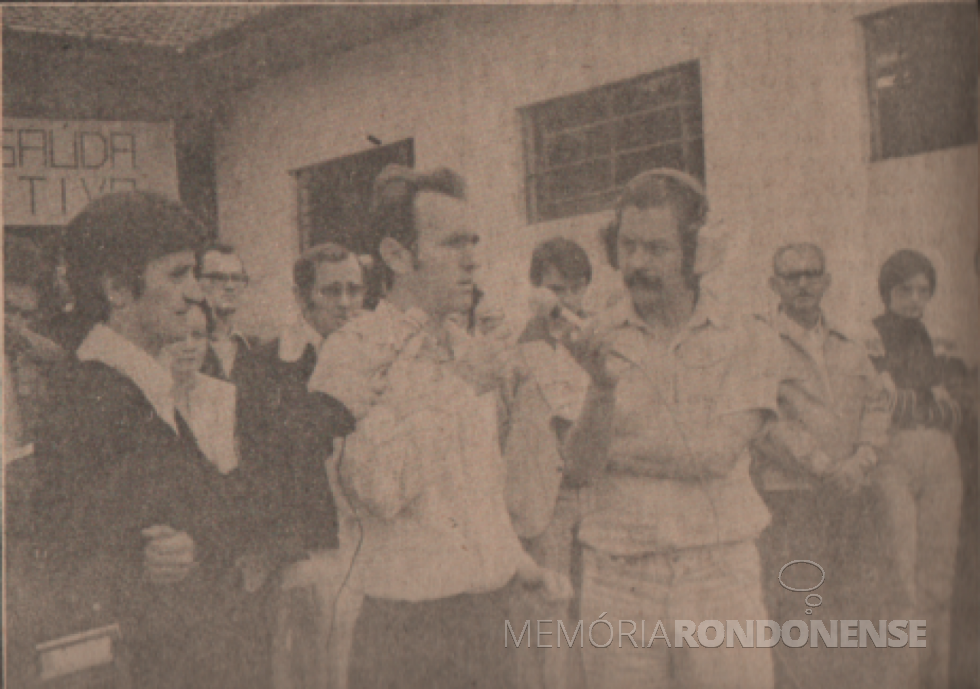 || Professor Olímpio Sauer saudando a instalação da Administração Pública Rondonense na sede distrital de Margarida, em agosto de 1978.
À esquerda, Egon Wanderer, da Rádio Educadora Marechal AM; e à direita, Dirceu da Cruz Vianna, repórter da Rádio Difusora do Paraná. Ambas emissoras da cidade de Marechal Cândido Rondon.
Imagem: Acervo Família Ariovaldo Luiz Bier/Projeto Memória Rondonense - FOTO 9 -