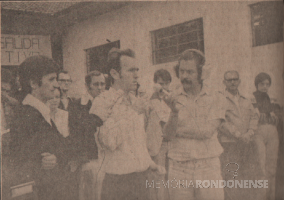 || Professor Olímpio Sauer saudando a instalação da Administração Pública Rondonense na sede distrital de Margarida, em agosto de 1978.
À esquerda, Egon Wanderer, da Rádio Educadora Marechal AM; e à direita, Dirceu da Cruz Vianna, repórter da Rádio Difusora do Paraná. Ambas emissoras da cidade de Marechal Cândido Rondon.
Imagem: Acervo Família Ariovaldo Luiz Bier/Projeto Memória Rondonense - FOTO 8 - 