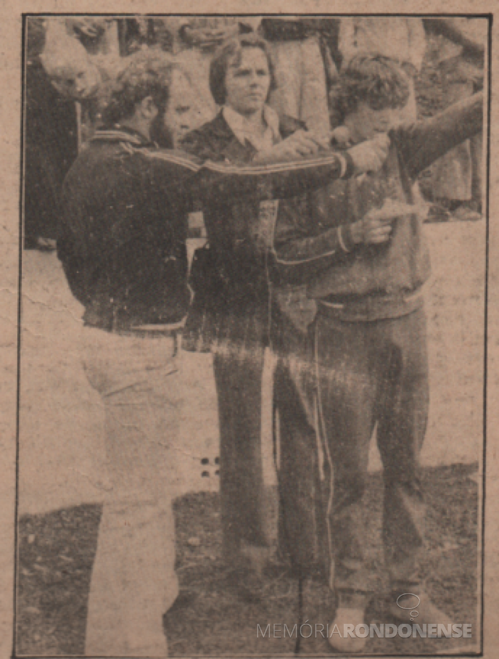 || Juramento do atleta rondonense Sérgio Drehmer na abertura dos Jogos Colegiais do Paraná 1978, fase regional, em agosto de 1978, ladeado por Egídio Scherer (e) e o jornalista rondonense Elio Edvino Winter, diretor da Rádio Difusora do Paraná. 
Imagem: Acervo Família de Ariovaldo Luiz Bier/Projeto Memória Rondonense - FOTO 10 -