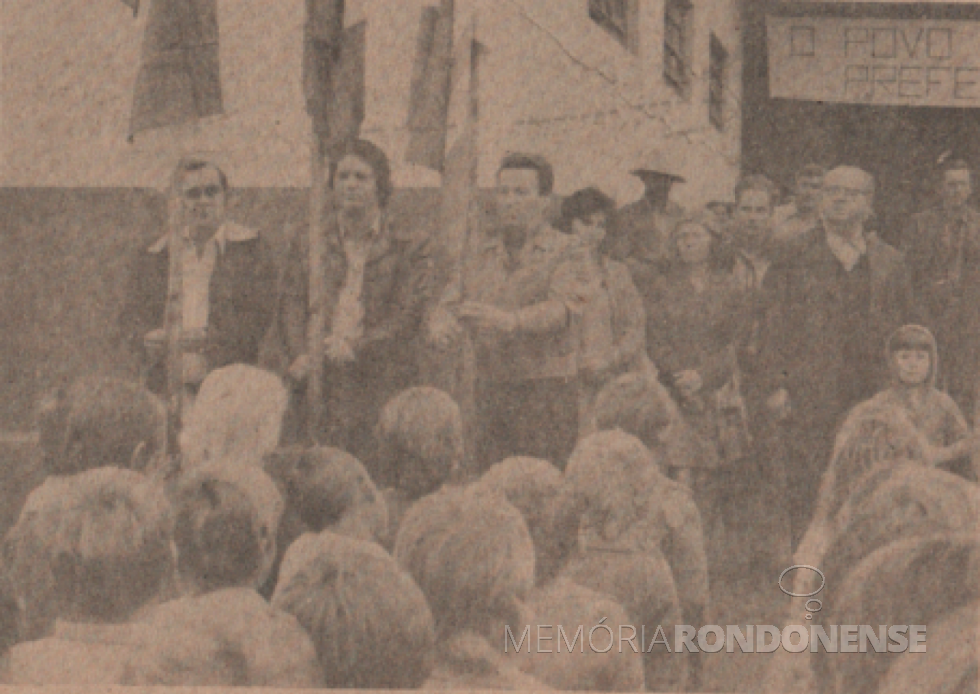 || Hasteamento das bandeiras na instalação da Administração Municipal de Marechal Cândido Rondon, na sede distrital de Margarida, em agosto de 1978.
Hasteiam as bandeiras: prefeito municipal Vernbo Scherer (e), deputado estadual Werner Wanderer (c) e  Germano José Kuhn (pioneiro do distrito rondonense citado. Ao fundo, de óculos, padre Vitoldo Kosicki, pároco da Paróquia Santa Margarida.
Imagem: Acervo Família Ariovaldo Luiz Bier/Projeto Memória Rondonense - FOTO 7 - 