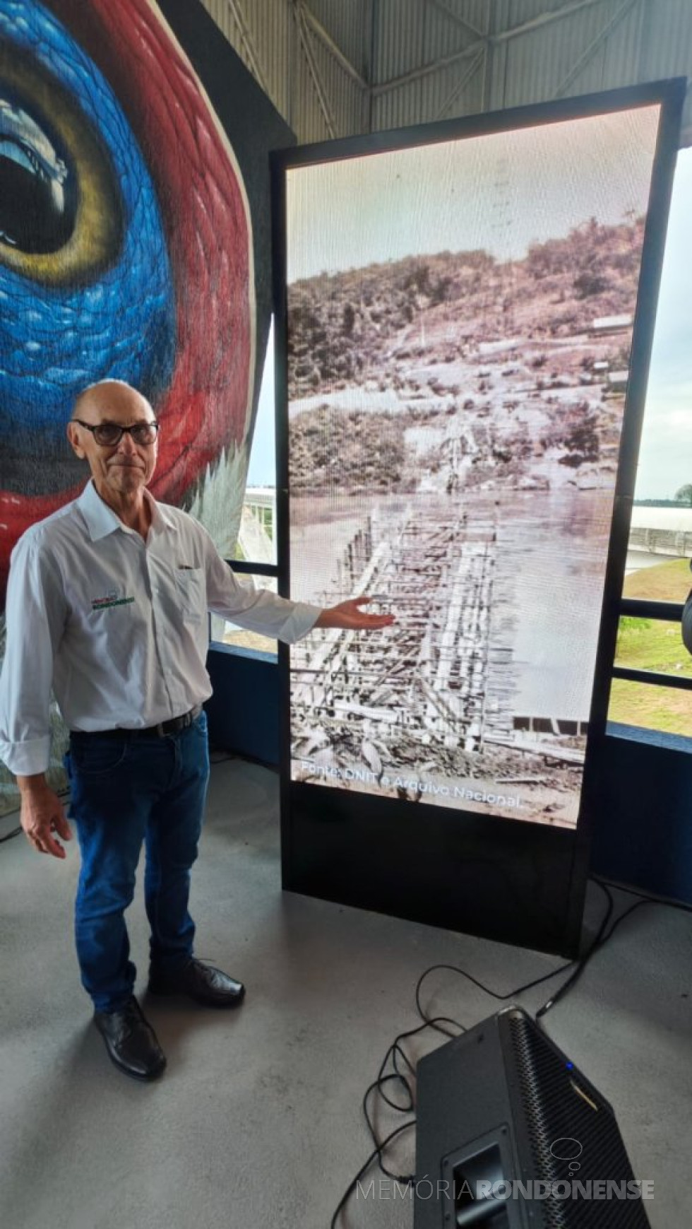 || Harto Viteck, coordenador do Projeto Memória Rondonense, junto ao painel rotativo de imagens históricas da Ponte da Amizade.
Imagem: Acervo projeto Memória Rondonense - crédito: Tioni de Oliveira - FOTO 26 -