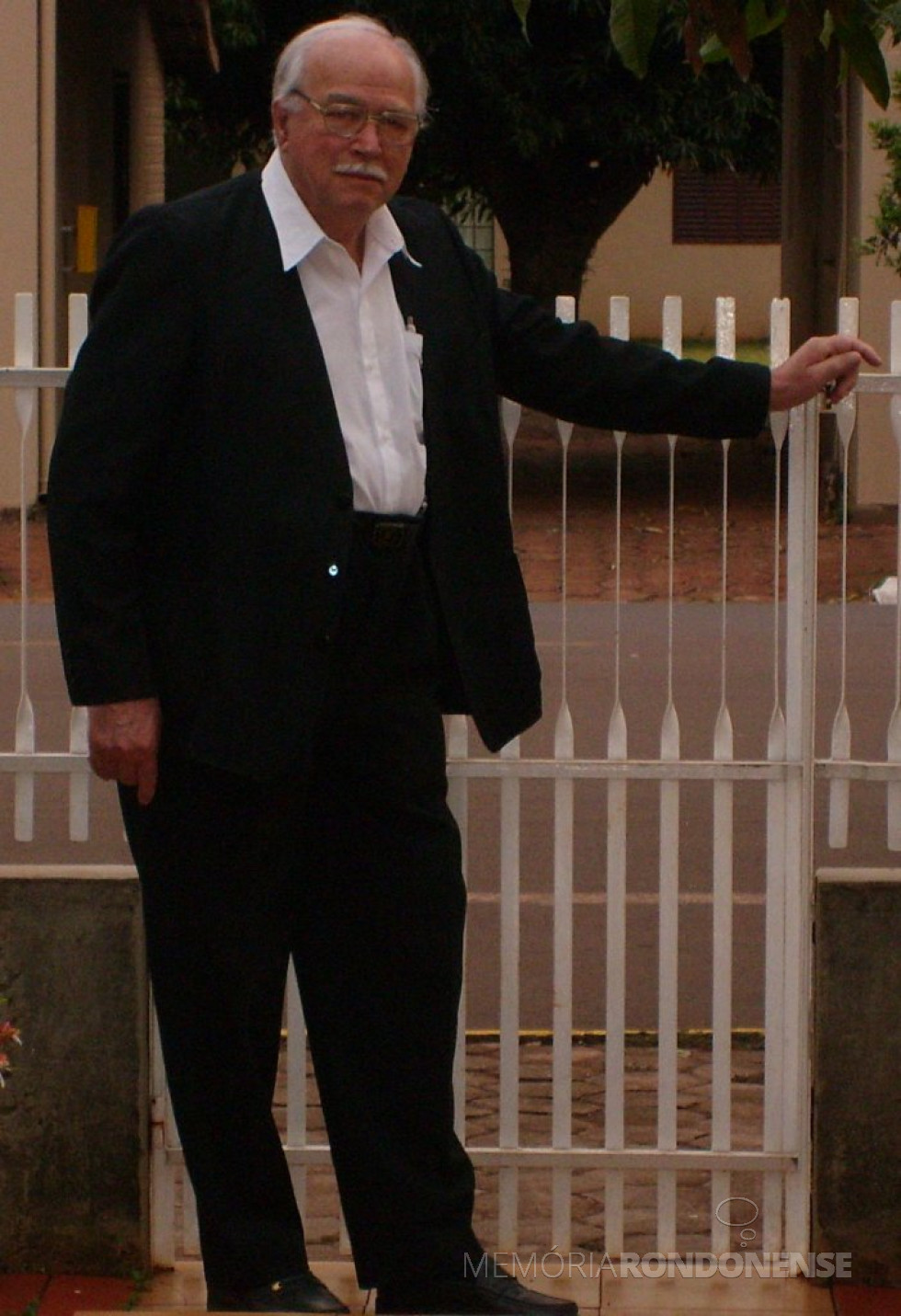 || Maestro e coralista Sigismundo Heinrich, falecido em fevereiro de 2011, fotografado no portão de acesso à sua residência em Marechal Cândido Rondon.
Imagem: Acervo Edela Heinrich - FOTO 14 -