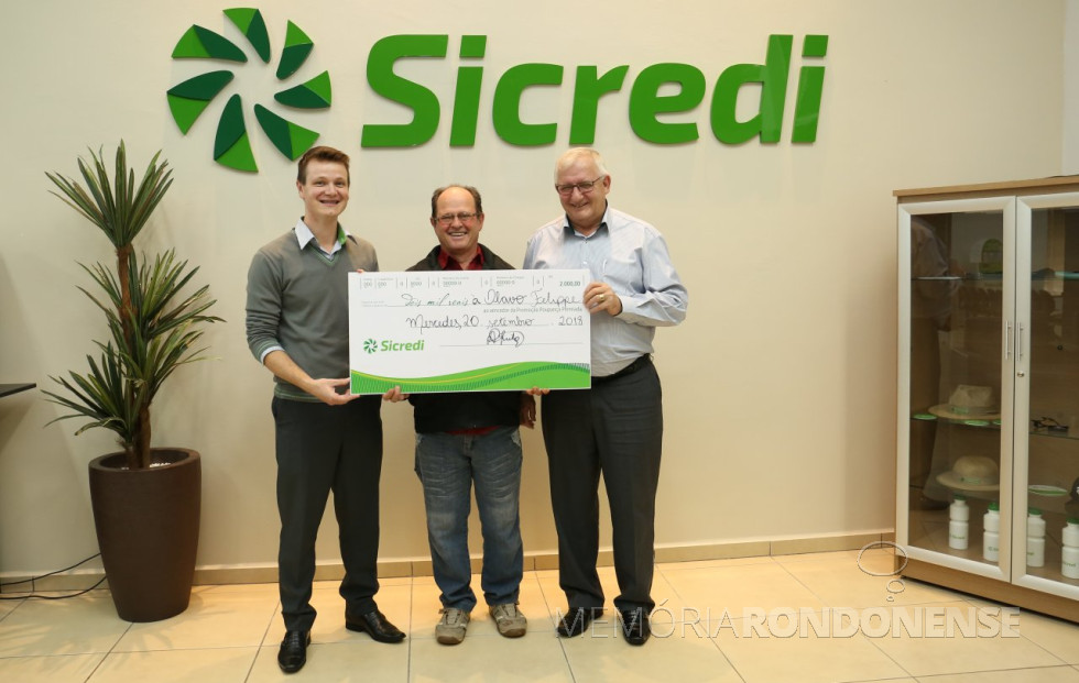 || Contemplado Olavo Felippe recebendo o prêmio de dois mil reais das mãos do gerente da agência de Mercedes, Álvaro Porto (e) e do diretor-presidente da Sicredi Aliança PR/SP, Adolfo Rudolfo Freitag, em setembro de 2018.
Imagem: Acervo Imprensa - Sicredi Aliança - FOTO 13 -