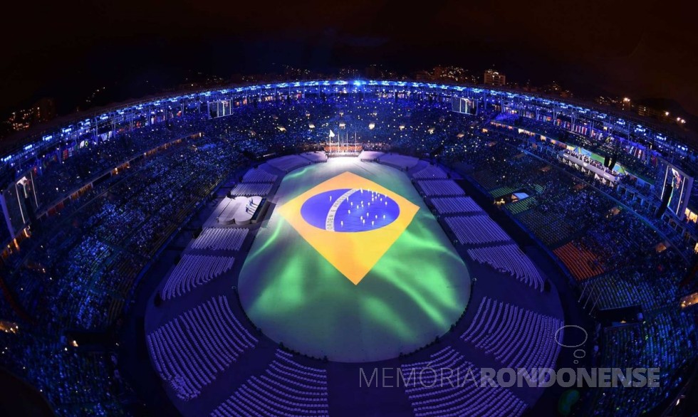 || Representação da bandeira nacional no tablado que cobria o gramado do estádio do Maracaná, durante a execução do Hino Nacional. 
Imagem: Reprodução - FOTO 9 - 