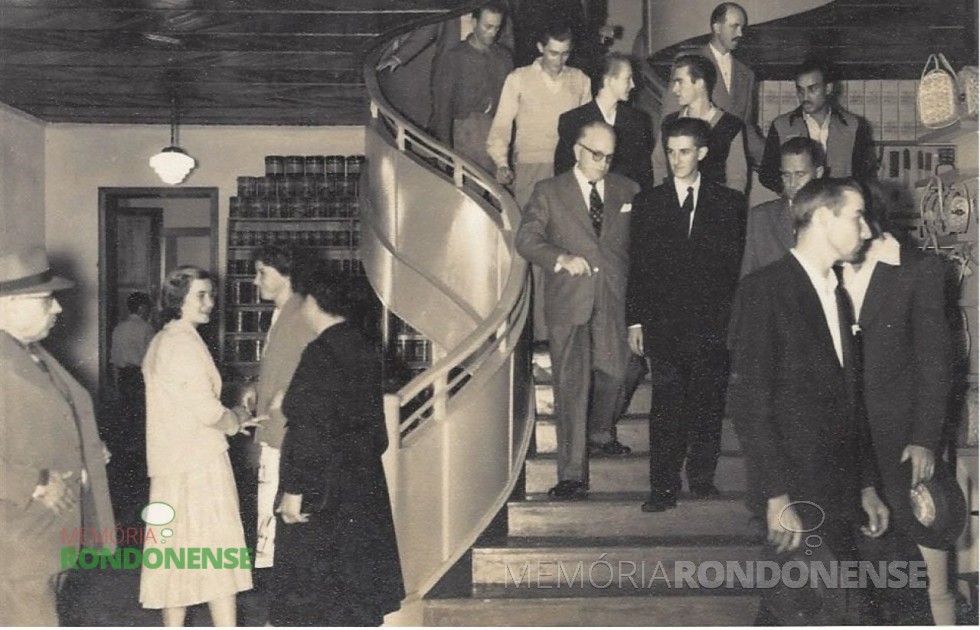 || Egon Pudell (de terno escuro e gravata - no centro), descendo a escada do mezzanino do Empório Toledo,  de propriedade da colonizadora Maripá, na companhia de convidados. 
Imagem: Acervo Família Seyboth - FOTO 1 - 