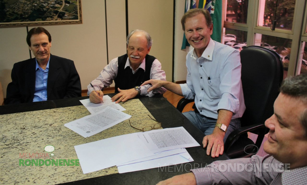 || Momento da assinatura da escritura pública da aquisição de área para o novo parque industrial de Marechal Cândido Rondon pelo senhor Osvino Ricardi - vendedor - e o prefeito municipal Moacir Froelich - pela compradora, a Prefeitura Municipal. 
Da esquerda à direita: advogado Itamar Dallagnol, empresário Osvino Ricardi, prefeito municipal Moacir Froelich, e Lair José Bersch, chefe de gabinete. 
Imagem: Acervo PM-MCR - FOTO 7 -