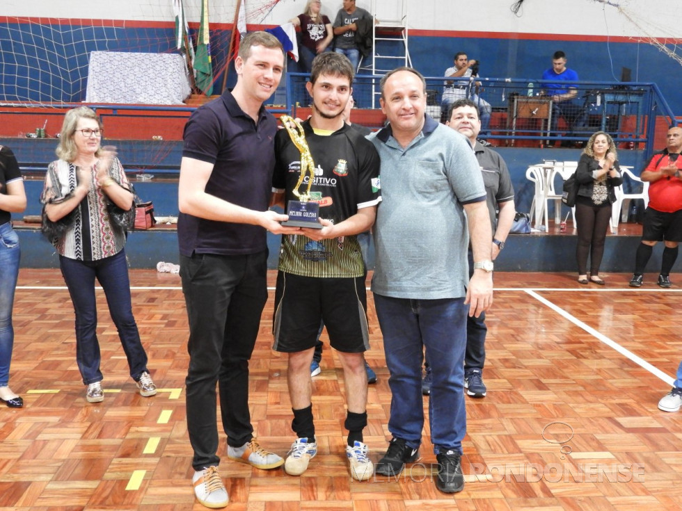 || Fabiano Bosembecker, da seleção de futsal de Quatro Pontes, recebendo o troféu de goleiro menos vazado da Copa Amop de Futsal 2018, ladeado pelo vice-prefeito Tiago Hansel (e) e pelo prefeito João Laufer. 
Imagem: Acervo Imprensa PM-Quatro Pontes - Crédito: Vanderleia Kochepka - FOTO 7 - 