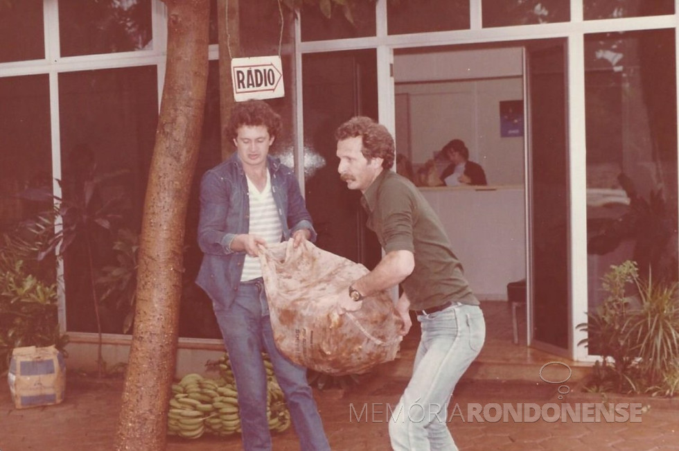 || Outro momento do carregamento dos donativos arrecadados. Da esquerda à direita: 1º - não identificado; e 2º - repórter Lincoln Leduc. No fundo, dentro do prédio, Ana Elisa Baumann, secretária da Rádio Difusora.
Imagem: Acervo Memória Rondonense - FOTO 8 -