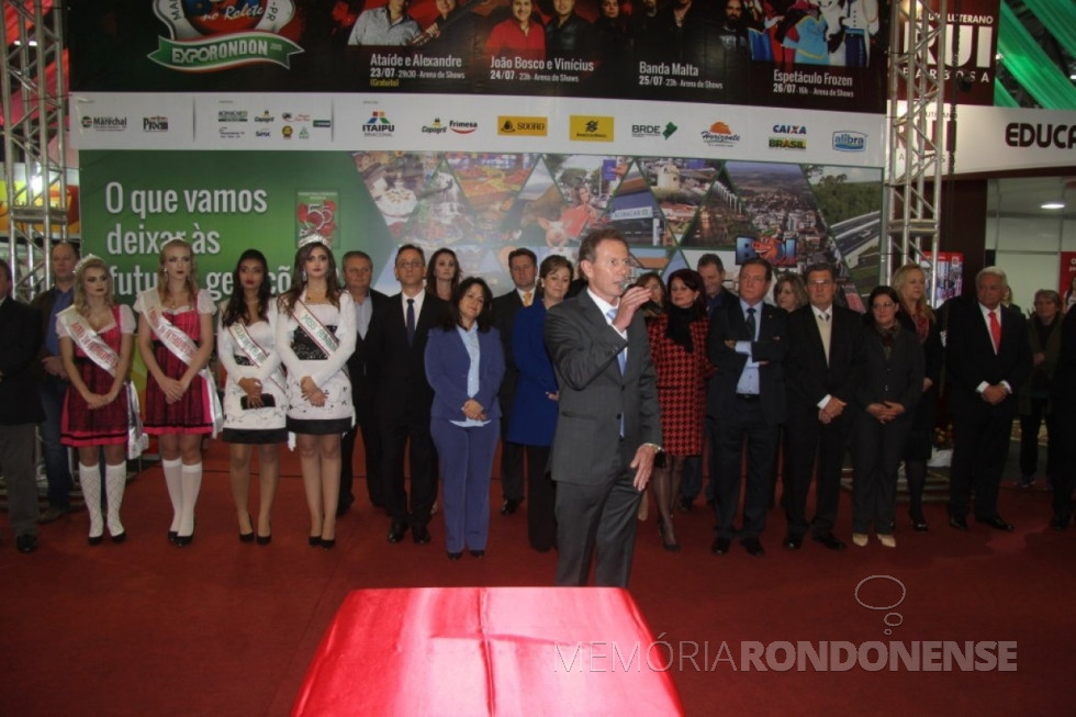 || Solenidade oficial da abertura dos festejos do 55º aniversário de Marechal Cândido Rondon, no hall de entrada do Parque de Exposições Álvaro Dias. 
Da esquerda à direita: 1ª a 4ª - não identificadas; 5ª - vereador Ari Hansen; 6ª - vereador João Marcos Gomes - Presidente da Câmara Municipal;   7ª - Carmen Borzatto, secretaria municipal de Cultura;  8ª - juíza de direito Berenice Nassar;  9ª - vereador Arlen Güttges;  10ª - Maria Cleonice Froelich, secretária municipal de Assistência Social;  11ª - Moacir Froelich, prefeito municipal;  12ª - não identificada;  13ª - Roseli Bier;  14ª - Clair Zóia - secretario municipal de Finanças; 15ª deputado estadual Ademir Bier;  16ª - não identificada;  17ª - vice-prefeito Silvestre Cottica;  18ª - esposa de Silvestre Cottica;  19ª - não identificada; e 20ª - Werner Wanderer. 
Imagem: Acervo Imprensa PM-MCR - FOTO 17 - 