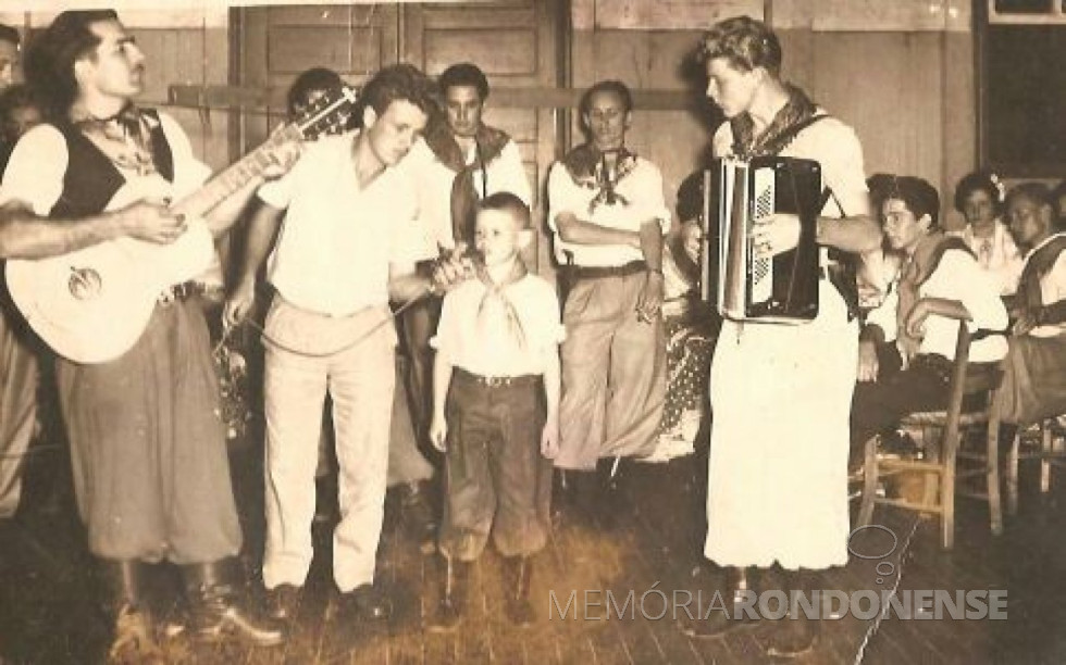 || Walter Basso (menino de 6 a 7 anos), se apresentando no baile estilo gaúcho, no então Salão Wayhs, em setembro de 1962.
Da esquerda à direita: 1ª - de violão, não identificado; 2ª - Ari Reis (Xuxú), de microfone; 3ª - Walter Basso; 4ª - Egon Seefeld, de acordeão. Demais pessoas não identificadas.
Imagem: Acervo Walter Basso - FOTO 1 -