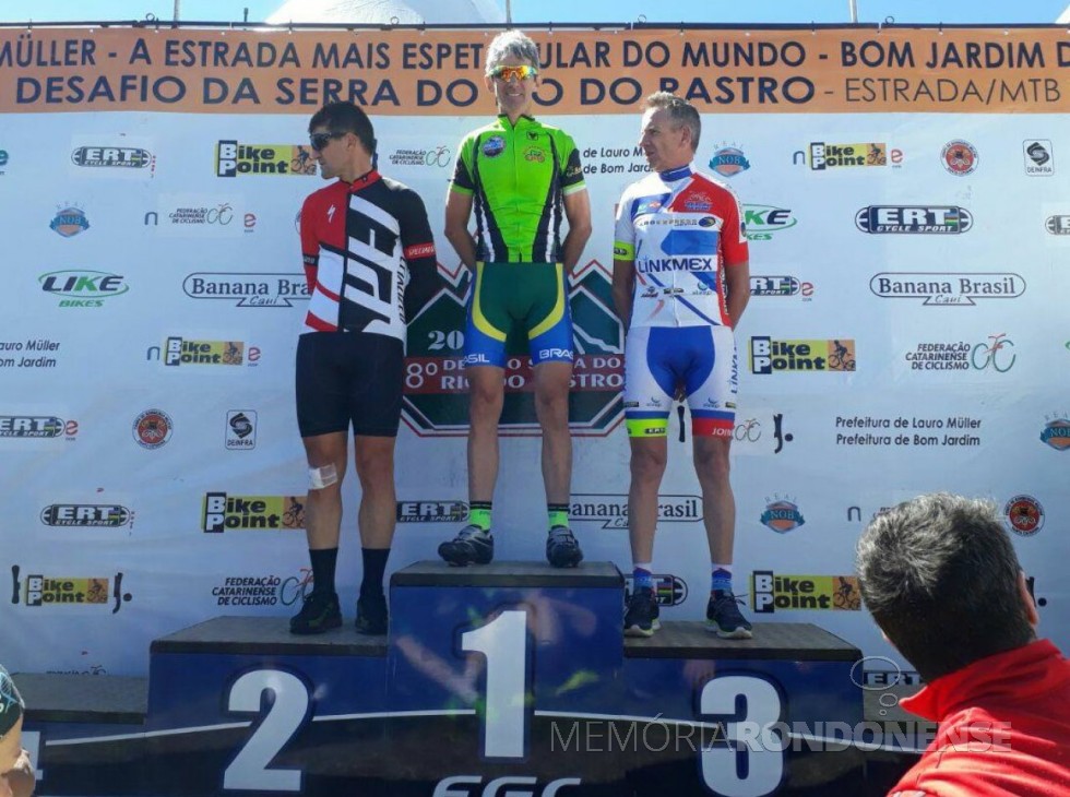 || Atleta rondonense Lirio Berwig no podium com o 2º colocado da competição, Almiro Antonio Krein e Vilmar de Souza, 3º colocado, ambos de Joinville, SC., em novembro de 2017.
Imagem: Acervo ARC - FOTO 7 - 