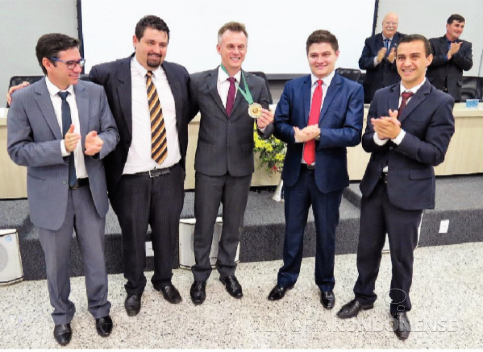|| Gerson Daniel Giese, dirigente de corais, com a Medalha de Honra ao Mérito de Marechal Cândido Rondon, entregue em agosto de 2019, ladeado da esquerda à direita: vereador Cláudio Köhler, presidente da Câmara Municipal; vereador Josoé Pedralli, vereador Arion Nasihgil e vereador Ronaldo Pohl.
Aos fundos, o radialista Dirceu da Cruz Vianna e o vereador Adriano Cóttica.
Imagem: Acervo O Presente - Crédito: Cristiano Marlon Viteck - FOTO 32 -