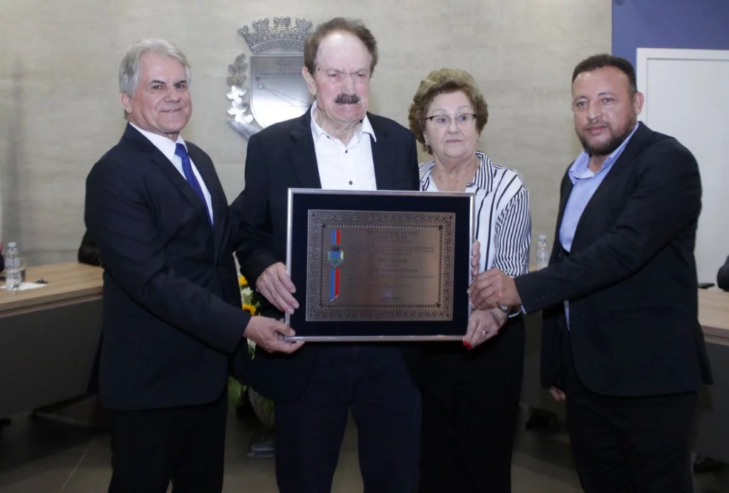 || Empresário Albino Giombelli homenageado com a comenda de cidadão honorário de Palotina, ladeado pelo prefeito do município, Luiz Ernesto de Giacometti (e), esposa Irma Therezinha e o vereador Nivair de Castro Souza, proponente da homenagem, em agosto de 2023.
Imagem: Acervo Gazeta de Toledo - FOTO 17 -