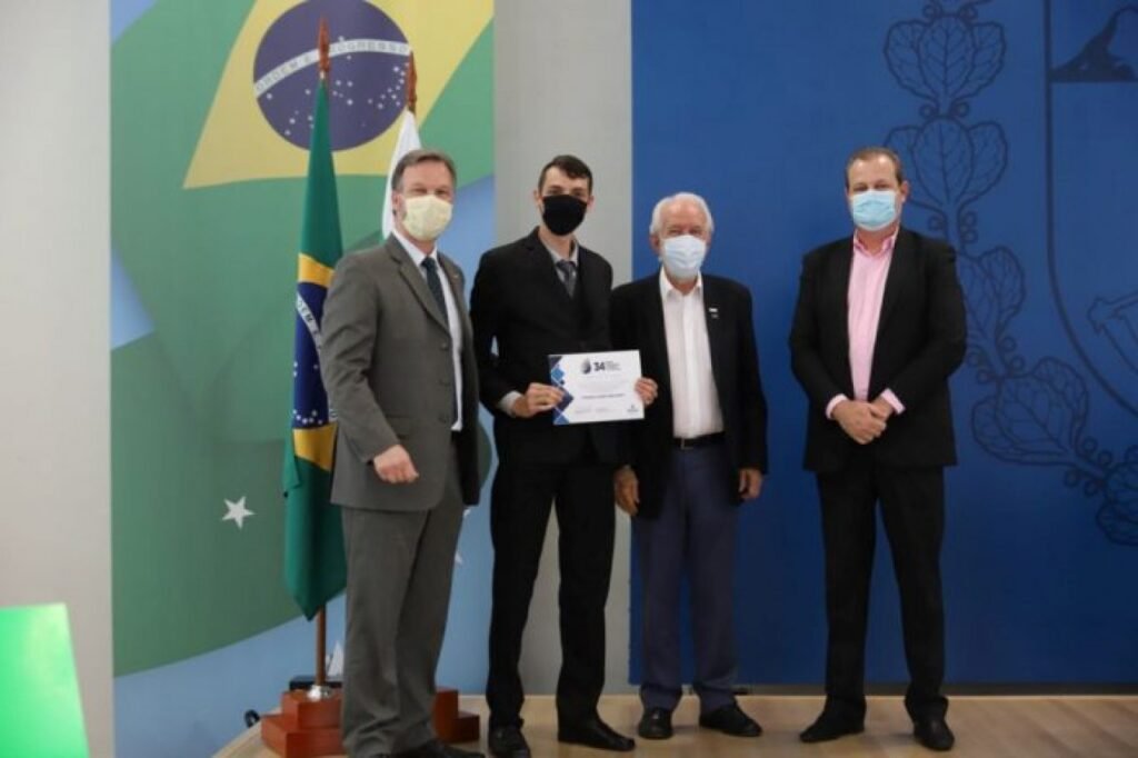 || Thiago Alessi Reichert  com o certificado de classificação Prêmio Paranaense de Ciência e Tecnologia 2021, ladeado pelo vice-governador Darci Piana(d) e representantes do órgão promovedor do concurso, em outubro de 2021.
Imagem: Acervo Gazeta de Toledo -  crédito: Geraldo Bubniak - FOTO 35 -