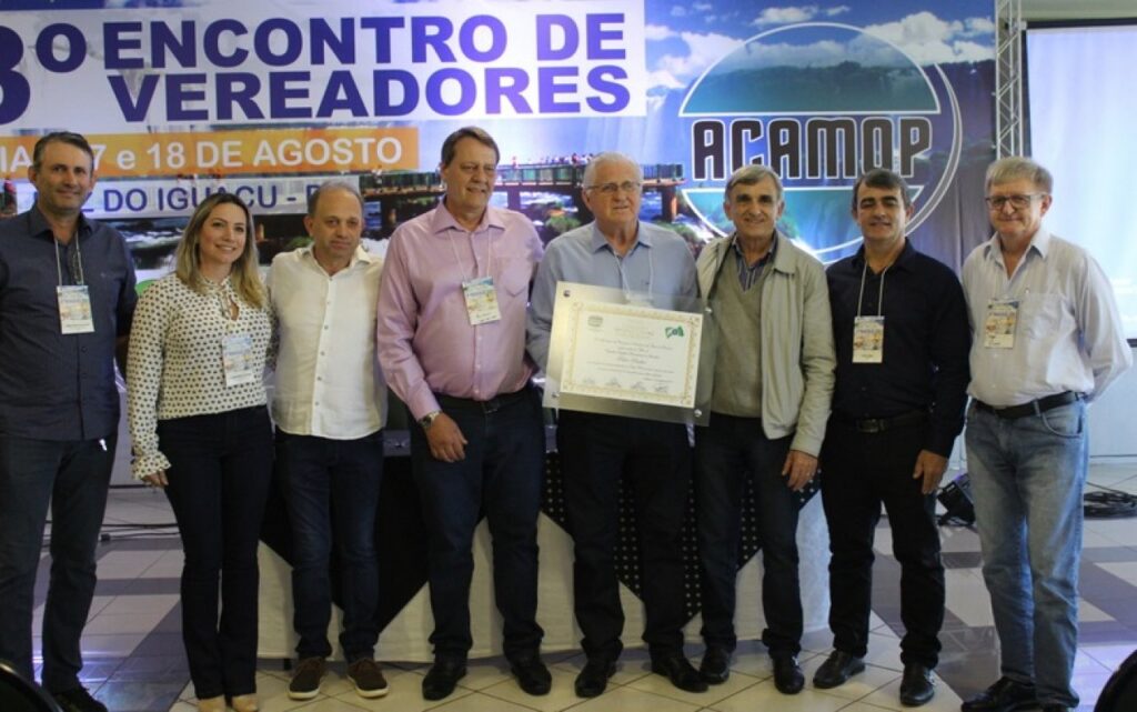 || Vereador Pedro Rauber recebendo o título de "Cidadão Orgulho Paranaense",   por decisão da ACAMOP., em agosto de 2017.
Da esquerda à direita: 1ª, 2ª, 3ªe  4ª - não identificadas; 5º - homenageado; 6º -
 vereador Júlio Morandi, da Câmara Municipal de Santa Helena; 7ª - vereador Euclides Kreutz, da Câmara Municipal de Maripá e 8ª - vereador José Schneider, da Câmara Municipal de Missal. 
Imagem: Acervo Câmara Municipal de Marechal Cândido Rondon - FOTO 22 -