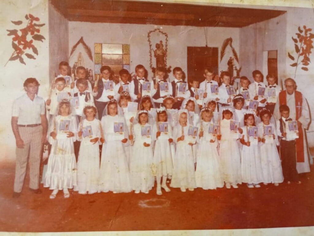 || Grupo de crianças de 1ª comunhão da Linha São Cristóvão, município de Marechal Cândido Rondon, com o padre João Assmann e o catequista Alceu Pedro Schneider, em outubro de 1979.
Imagem: Acervo Carlos Paulo Macedo/ Facebook - FOTO 10 -