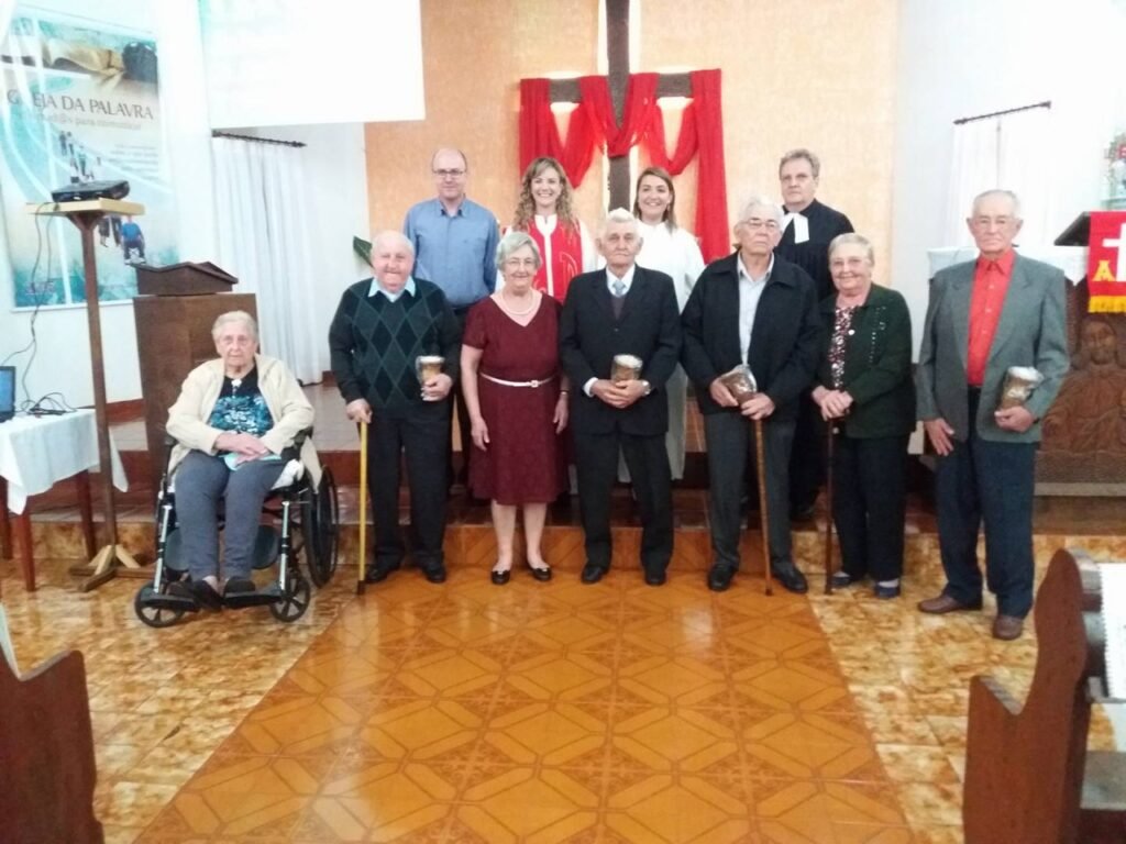 || Grupo de membros fundadores  da Comunidade Evangélica de Iguiporã homenageados na comemoração dos 60 anos de fundação da comunidade. Da esquerda à direita, a frente: casal Francisco Vilma (Hassemer) e Osvino Ernesto Wolfart; casal Ella (Lang) e Edvino Koch; casal Edmundo e Gertrudes (Lang) Koch; e Arnaldo Storck (viúvo), cunhado de Edvino e Edmundo Koch. 
Imagem: Acervo Paróquia Evangélica Esperança em Cristo - FOTO 25 -
