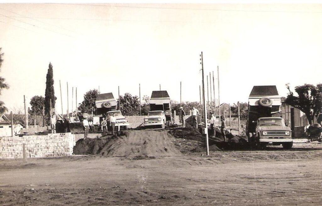 || Caminhões da Prefeitura Municipal de Marechal Cândido Rondon com cargas de terras para o aterramento do  alicerce da atual Igreja Luterana Cristo.
Imagem: Acervo da históriadora rondonense Lori Speck - FOTO 17 -