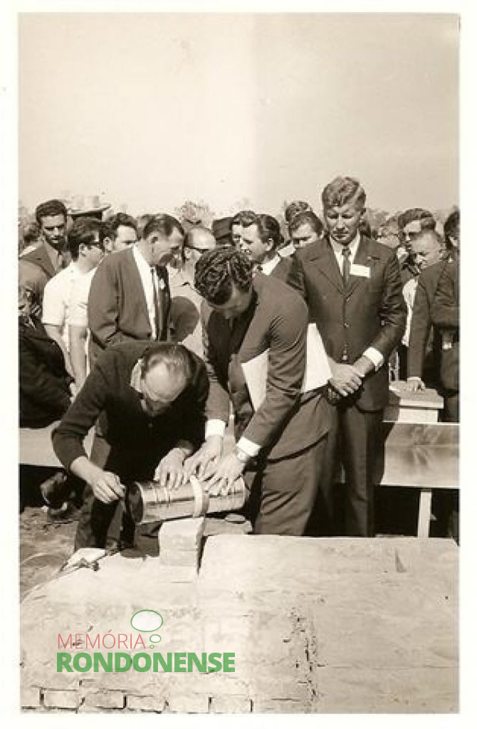 Momento em que era lacrada a cápsula dos documentos constitutivos do SAAE para ser fixada na estrutura da “pedra inicial” da autarquia. 
À esquerda, o sr. Arlindo Alberto Lamb em conversa com um convidado; e a direita o Prefeito em exercício Dealmo Selmiro Poersch, de mãos cruzadas. 
Imagem: Acervo SAAE-MCR